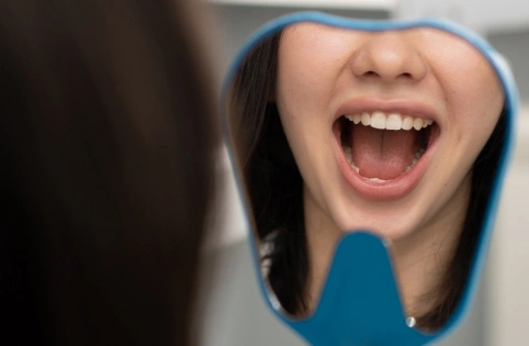 Happy woman in blue hood smiling brightly, dental care context.