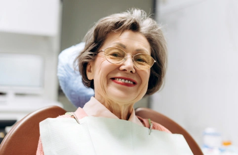 Smiling woman in dental chair receiving treatment at Dream Dental & Sleep clinic.