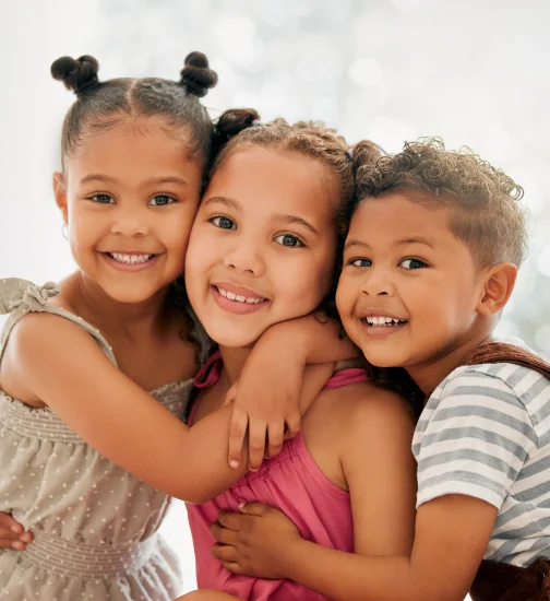 Three smiling children hugging at Dream Dental & Sleep a kid-friendly dentist in Hermitage, PA